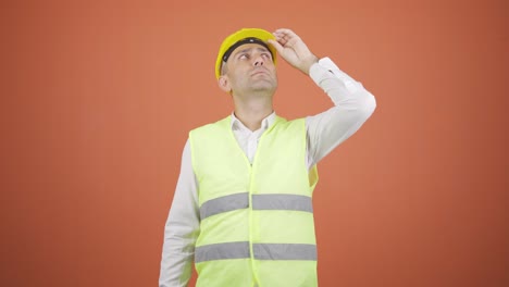 Looking-up,-the-engineer-is-holding-his-hard-hat.